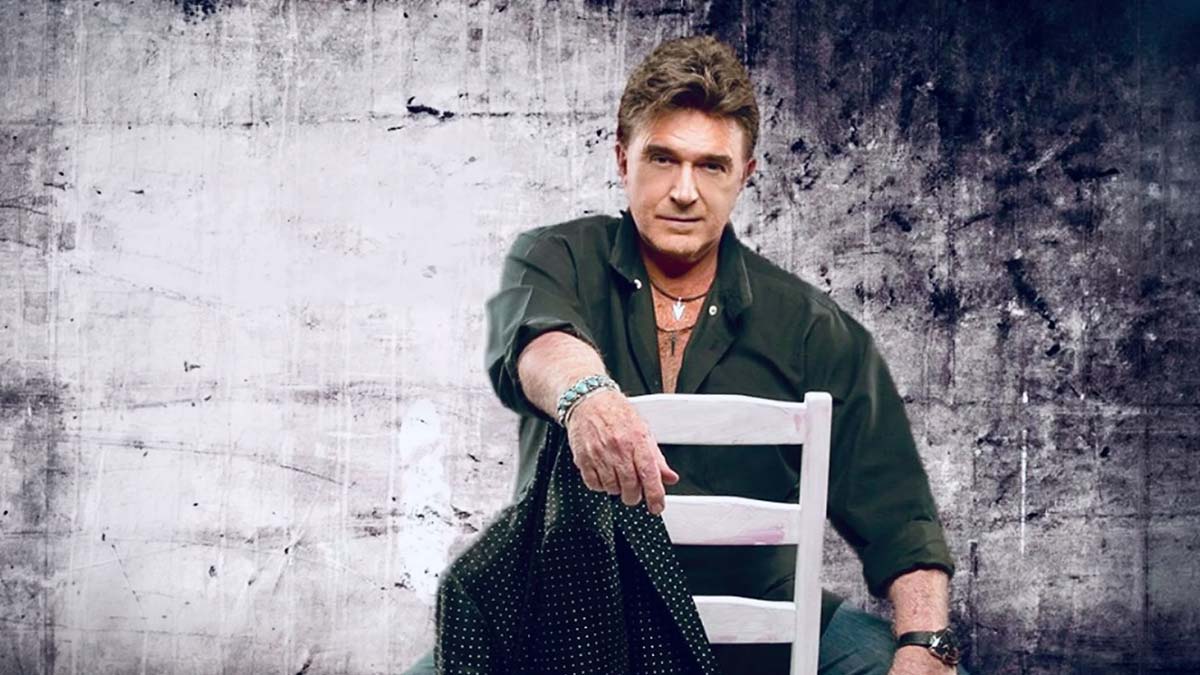 A man in a dark shirt sits on a white chair at T.G. Sheppard Rib Fest 2026.