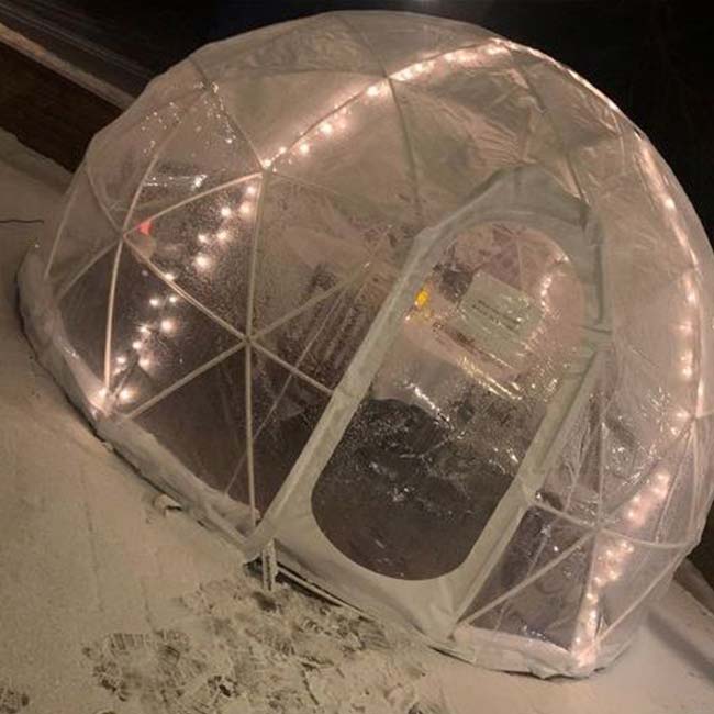 A transparent dome igloo lit with string lights, perfect for weddings or banquets in Watertown MN.